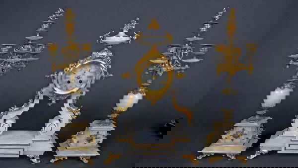 French Gilt Metal and Alabaster Clock Garniture: Neoclassical style clock with a pair of 3-light candelabra. Clock height 19 inches.