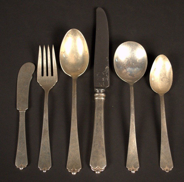 Watson Sterling Silver Flatware: Lotus pattern, comprising five dinner knives, six table spoons, three cream soup spoons, three salad forks, two teaspoons and a butter spreader. Total approximately 22 ounces.