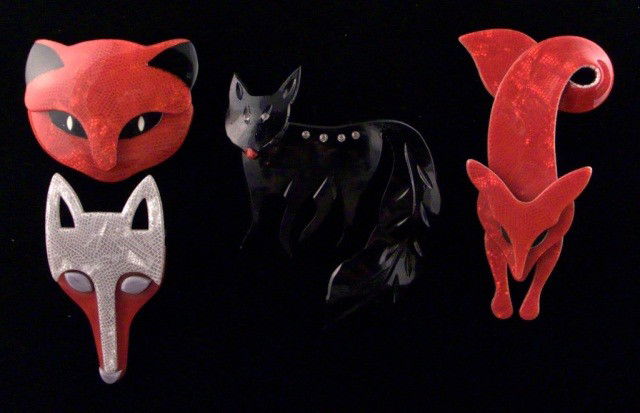 Three Lea Stein, Paris Fox Pins *: Comprising two red fox head pins, a red fox pin, all signed; together with an unsigned black fox pin. Red fox pin 3 3/4 x 2 inches.