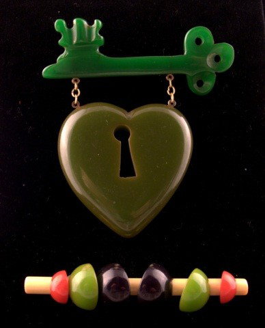 Key & Heart and Bar Bakelite Pins: Green key suspending a heart with keyhole and a a bar pin decorated with various colored semi circles. Heart 3 inches, bar pin 3 1/2 inches.