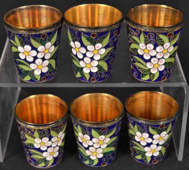 Russian Silver Gilt and Enamel Shot Glasses *: Six pieces with white floral decoration on a cobalt ground. Height 1 3/4 inches.