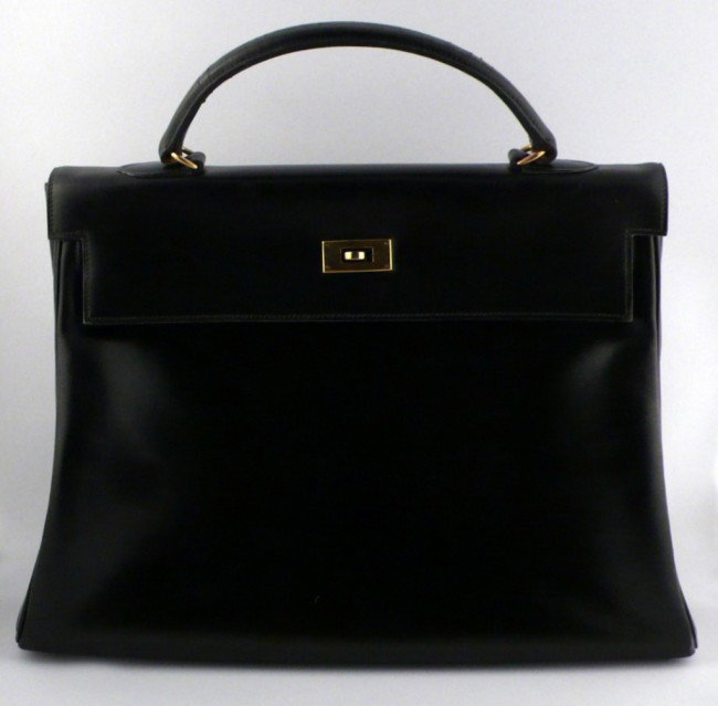 Hermes Kelly Bag: Black smooth leather with brass fittings, lock and key. Height over handle 13 inches, width at bottom 13 1/2 inches.