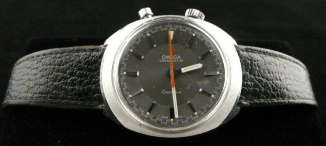 Omega Chronostop Watch: Chrome case, dark grey dial with batons, black leather band.