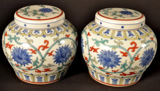 Pair of Asian Porcelain Ginger Jars: Covered jars decorated with blue chrysanthemums and hightlighted with red accents. Height 5 inches.