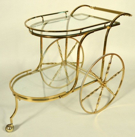 Brass Tea Cart: Two glass shelves on a brass cart with large wagon wheels. Height 32 inches, width 40 inches, 22 inches.