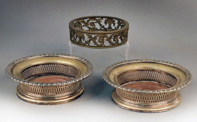 Pair of Wine Coasters: English silver plated, gadrooned rim, recticulated sides and turned wood bottom, height 2 inches, diameter 7 inches; together with a floral decorated metal dish ring, diameter 5 1/2 inches.
