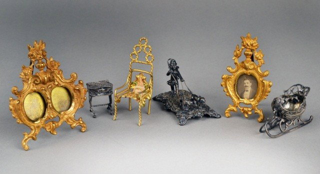 Miscellaneous Group of Miniatures: Comprising two Rococo style gilt bronze picture frames, side chair, German silver sleigh, filigree work table, and a Continental silver miniature of a putto walking two dogs. Largest picture frame 3 1