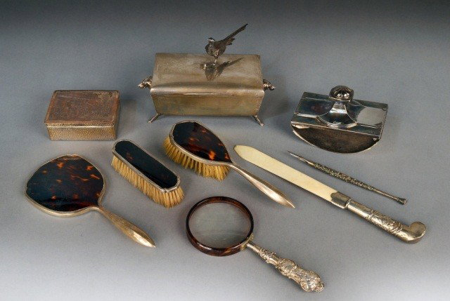 Miscellaneous Group of Desk & Dresser Articles: Comprising two silver plated humidors, sterling silver dip pen, silver mounted ivory page turner, sterling handled magnifier, a blotter and a three piece dresser set including hand mirror, hair brush 