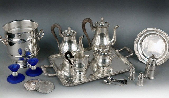 Group of Christofle Silver Plated Table Articles: Comprising a five piece coffee and tea service, castor, pair of shakers, set of coasters, pair of candlesticks, champagne bucket, plate, and a set of coffee spoons.