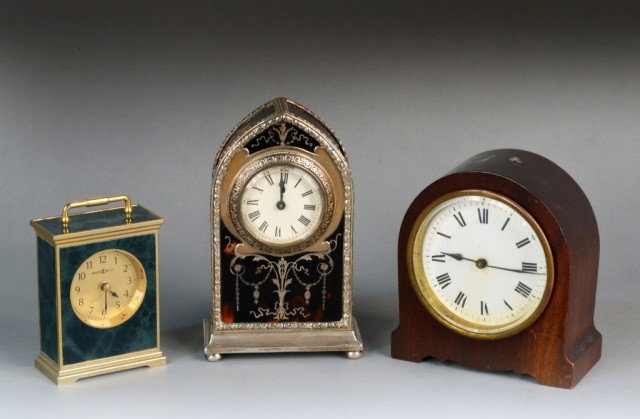 Three Desk Clocks: One, an English silver mounted tortoise case clock, another a Howard Miller simulated malachite case clock, and the third, a mahogany case clock. Tallest 6 1/2 inches.