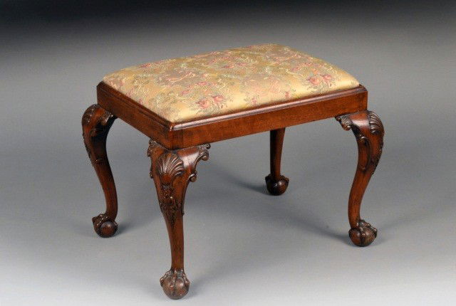 English Mahogany Chippendale Style Foot Stool: Rectangular form with over upholstered slip seat, raised on four cabriole legs with shell carved knees terminating on ball in claw feet. Height 19 inches, width 25 inches, depth 19 inches.