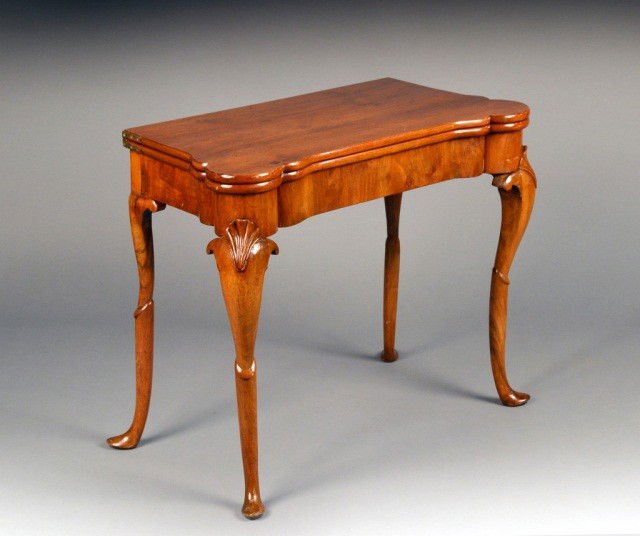 Queen Anne Style Walnut Game Table: Rectangular fold top with outset corners, opening to a baize lined interior with cups, on shell carved double scroll cabriole legs ending in hoof feet. Height 27 3/4 inches, width 32 1/2 inches, depth