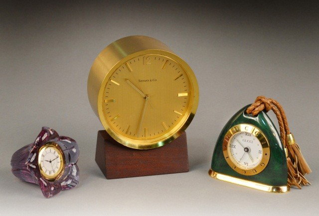 Three Desk Clocks: By various makers, including Tiffany & Co. and Gucci. Tallest 5 1/2 inches.