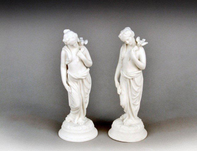 Pair of Parian Porcelain Figures of Maidens: Each depicting a classical maiden with a dove on her shoulder. Height 10 1/2 inches.