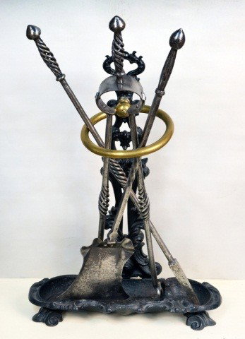 Set of Fire Tools With Stand: Comprising a poker, shovel and tongs on a rococo style cast iron stand. Stand height 26 inches.
