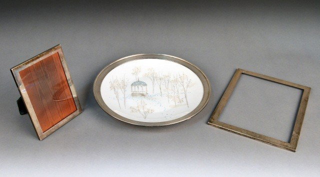 Three Sterling Silver Articles: (1) Rosenthal sterling silver mounted charger, "Rendezvous" designed by Raymond Loewy; (2) Gumps sterling picture frame, 7 x 5 inches; and (3) a Raimond sterling picture frame, missing the back, 10 x 