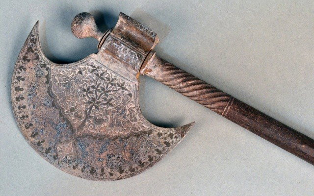 Indo-Persian Qajar Dynasty Style Ceremonial Axe: Cresent blade with etching on both sides, atop a chased and molded ornamental haft. Length 29 1/2 inches.