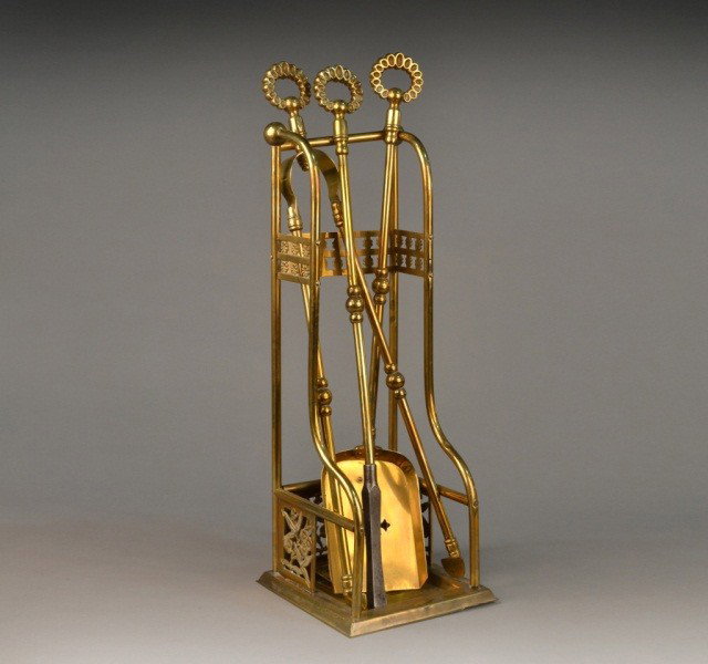 Set of Aesthetic Movement Brass Fireside Tools: Late 19th century, comprising a shovel, poker and tongs with stand. Height 24 inches.