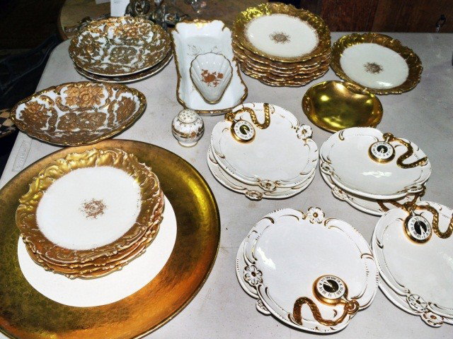 Group of Gilt Decorated Porcelain Table Articles: Comprising a set of eight watch decorated plates; two sets of Limoges gilt rimmed dessert plates; candy dish, relish dish; a pair of plates and a lozenge dish with raised decoration; a circular tray; 