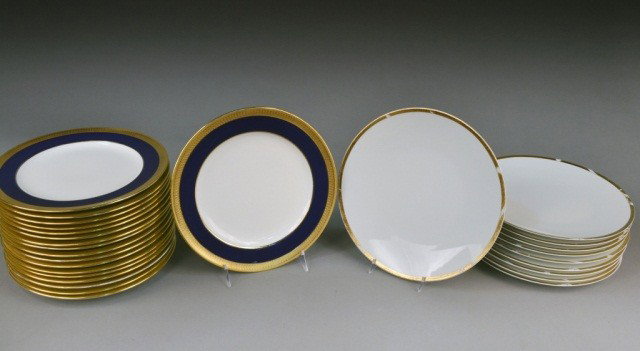Two Sets of Porcelain Plates: One, a set of eighteen Mintons porcelain dinner plates with cobalt and gilt border, pattern S6262; and the other, a set of French porcelain gilt decorated white dinner plates. Mintons plates diameter 