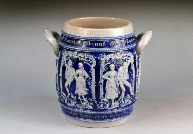 Mettlach Stoneware Vessel: All around figural decoration, with acanthus capped handles. Height 12 inches.