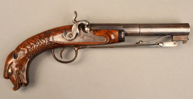 Continental Boarding Pistol: 19th Century, wood carved stock with mythological sea creature decoration and a spring action bayonet style blade. Length 13 inches.