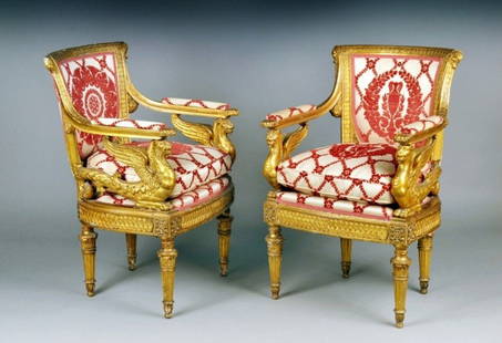 Pair of Louis XVI Gilt Wood Fauteuils: Late 18th century, having laurel leaf carved rails on a trapezoid shaped upholstered back and padded arms on griffin supports, slightly bowed seat and tapered fluted legs. Height 35 1/2 inches,