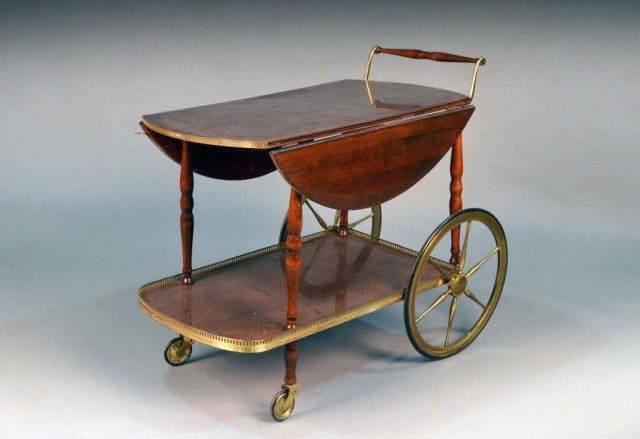 Modern Two Tier Tea Cart: Mahogany rectangular top with two drop leaves on turned supports, joined by a lower shelf, with brass gallery. Height 30 inches, width 36 inches, depth 18 1/2 inches.