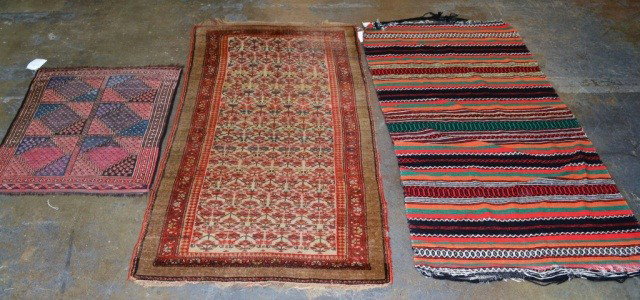 Group of Three Throw Rugs: (1) Caucasian carpet with allover geometric design in pink,blue, and brown. 40 x 33 inches; (2) Middle Eastern carpet with allover stylized floral design on an ivory field within three guard borders. 