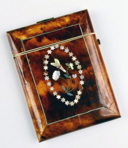Tortoiseshell Card Case: 19th century, with abalone inset floral decoration surrounded by a ring of mother of pearl stars. 3 3/4 x 2 3/4 inches.