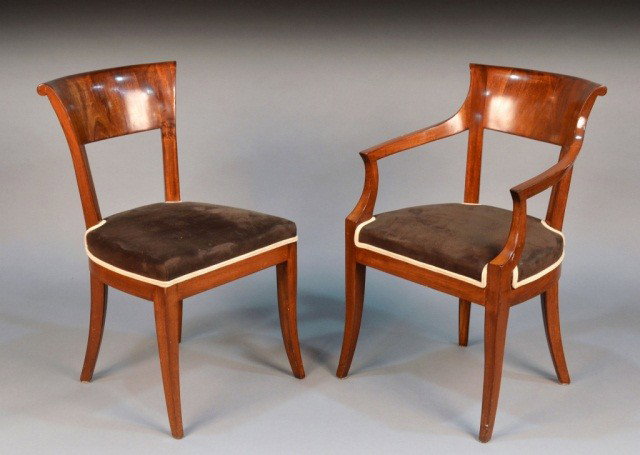 Set of Four Biedermeier Walnut Chairs: Comprising two side chairs and two open armchairs. Over upholstered, raised on four sabre legs. Height 32 inches, width 21 inches, depth 18 inches.