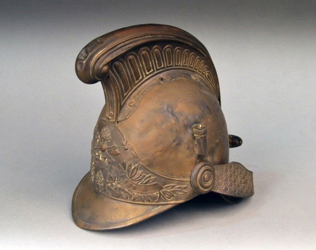French Antique Brass Fireman's Helmet: Mid/late 19th century, with raised laurel, crossed axe, and fire decoration, and inscribed "Srs Pompiers De Ver." Height 10 1/2 inches.