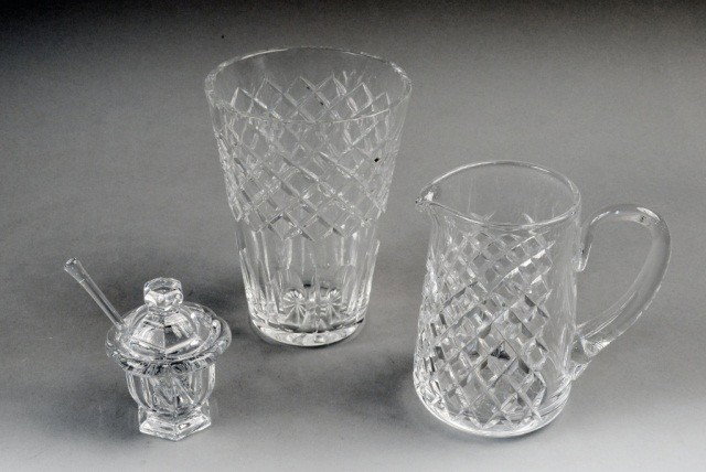 Three Cut Glass Table Articles: Including a Baccarat jam jar, an Orrefors pitcher, and a Waterford style vase. Vase height 12 inches.