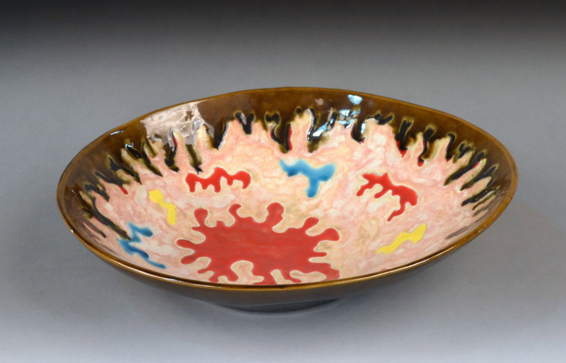 Claude Renoir Glazed Ceramic Bowl: Glazed decoration of amorphous figure on a pink ground within a brown border, signed. Diameter 13 inches.