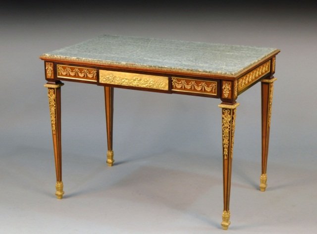 Louis XVI Style Bronze Mounted Center Table: Mottled green marble top above a single long drawer with gilt metal swag decoration, square tapered legs ending in sabot feet. Height 29 1/4 inches, width 39 inches, depth 25 1/4 inches.