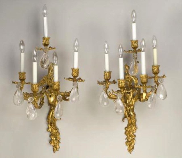 Pair of Louis XV Style Gilded Bronze Sconces: Five arm, acanthus leaf and floral cast motif with rock crystal pendants. Height 25 inches, width 15 inches.