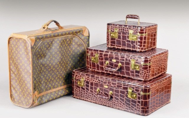 Louis Vuitton Suitcase & Three Piece Luggage Set: Soft sided Louis Vuitton case with leather trim, together with three-piece simulated alligator luggage set. Louis Vuitton case, height 8 inches, width 26 inches, depth 20 inches.