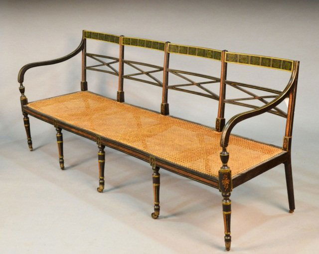 Regency Black Painted Settee: Ivy leaf stencil painted tablet crest rail, open arms, caned seat, turned tapered legs ending in brass casters. Height 33 1/2 inches, length 7 feet depth 24 inches.