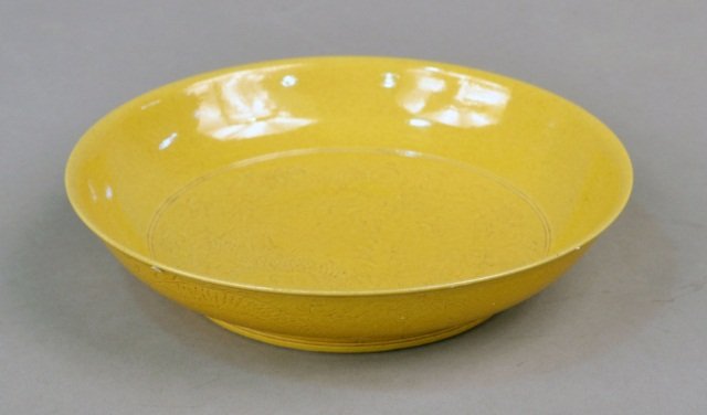 Chinese Porcelain Monochrome Yellow Glazed Plate: Center incised with a fierce five clawed dragon contesting the flaming pearl within a double circle border, exterior incised with two five-clawed dragons amidst flames and clouds, contesting the pearl