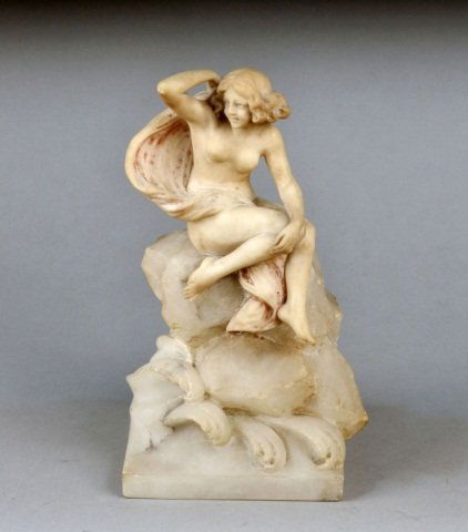 Alabaster Figure of a Siren: Carved seated on a rock surrounded by waves, square base. Height 13 1/4 inches.