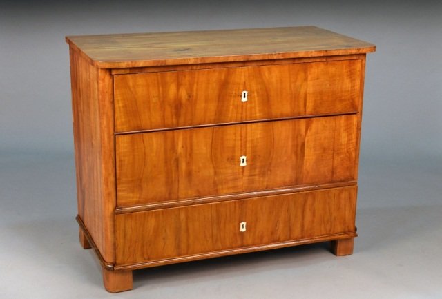 Biedermeier Style Fruitwood Commode: Rectangular top with rounded corners above three drawers with ivory escutcheons, plinth base. Height 33 1/4 inches, width 42 inches, depth 21 inches.