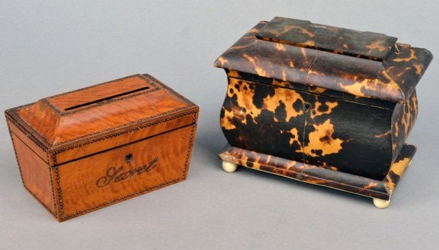 Two English Boxes: Early 19th century. One, a tortoise shell tea caddy raised on ivory ball feet; the other, ambroyna wood casket form box with raised decoration. Tea caddy, height 6 3/4 inches. Provenance: Estate of Mi