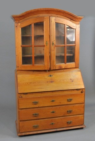 Scandinavian Stripped Pine Secretary / Bookcase: Arched top above two glazed doors, slant front desk above three long drawers. Height 79 inches, width 45 inches, depth 19 1/2 inches.