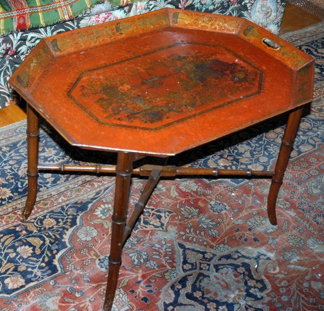 Red Tole Tray on Stand: Rectangular tray with cut corners, gilt decoration, on a faux bamboo stand. Height 20 inches, width 30 inches, depth 21 1/4 inches. Provenance: Estate of Michael "Mendy" Wager.