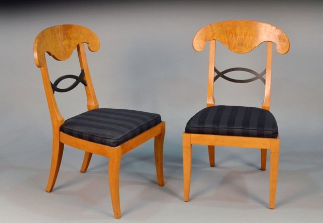 Set of Four Biedermeier Style Dining Chairs: By Baker, with a shaped crest rail above an ebonized horizontal pierced splat, upholstered seat, atop splayed legs. Height 37 inches, width 22 inches, depth 21 inches.