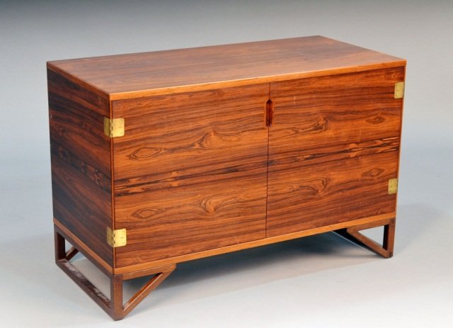Scandinavian Rosewood Two Door Cupboard: Mid century modern style, Rectangular top above two cupboard doors with brass accents, raised on pierced fruitwood base. Height 26 inches, width 39 1/2 inches, depth 18 1/2 inches.