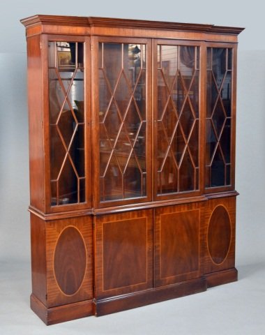 Baker Mahogany Breakfront: Georgian style with molded cornice above four glazed doors. The base with four inlaid doors, plinth base. Height 7 feet, width 69 inches, depth 16 inches.
