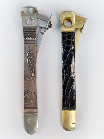 Two Cigar Cutters: One, Georg Jensen with sterling silver handle stamped 42A, length 6 1/2 inches; the other, brass with a leather handle.