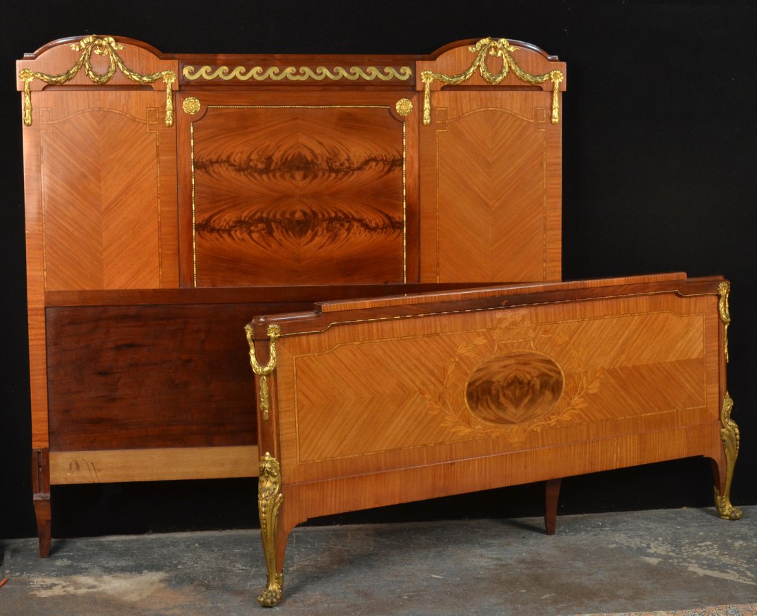 Neoclassical Style Gilt Metal Mounted Bed: Ribbon, wreath and scroll decoration, with cross-banded and marquetry inlay, legs ending in scroll and paw sabot. Height 61 inches, width 64 inches, length 7 feet 3 inches.