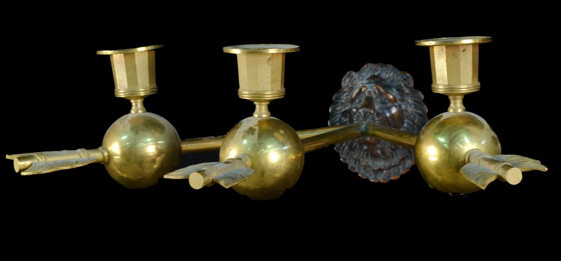 Set of Four Neoclassical Style Sconces: Gilded bronze, three arm sconces in arrow motif and lion's head back plate. Height 6 inches, width 14 inches, depth 12 inches.